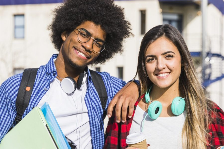 casal-de-raca-mista-feliz-posando-em-frente-ao-predio-da-universidade – Copia
